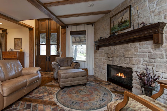living room featuring french doors, brick floor, beamed ceiling, and a fireplace