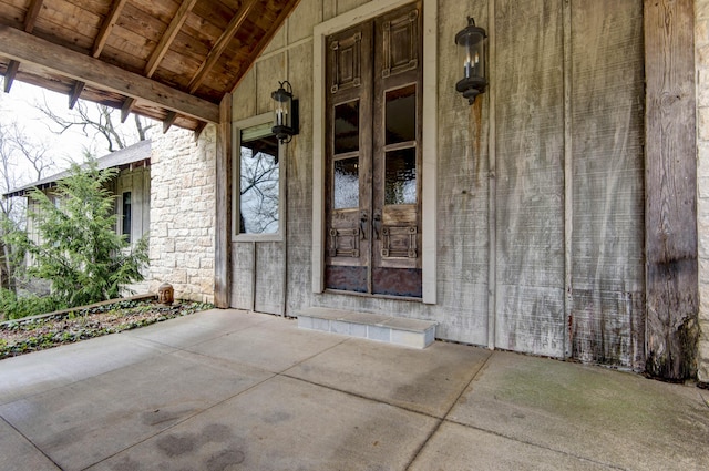 entrance to property featuring stone siding and french doors