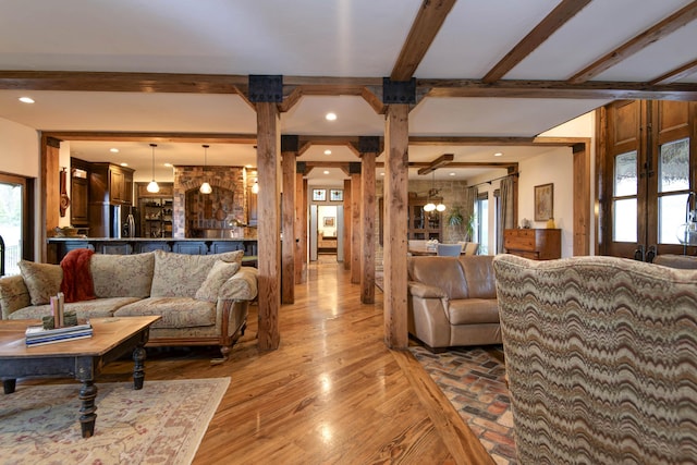 living area with ornate columns, light wood-style flooring, recessed lighting, and beamed ceiling