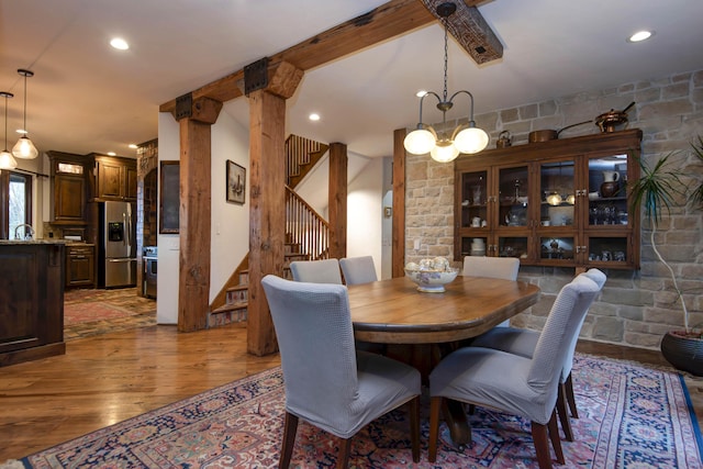dining room with light wood-style floors, stairway, beamed ceiling, and recessed lighting