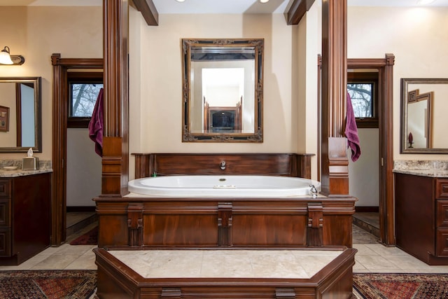 bathroom with a garden tub, tile patterned flooring, and two vanities