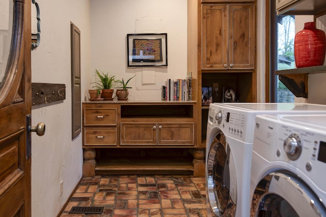 clothes washing area with independent washer and dryer, cabinet space, brick floor, and visible vents