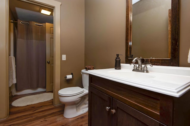 full bathroom with toilet, vanity, curtained shower, and wood finished floors