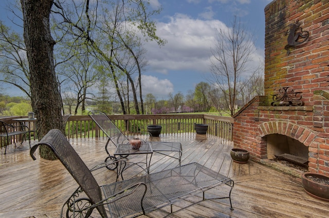 deck featuring an outdoor brick fireplace