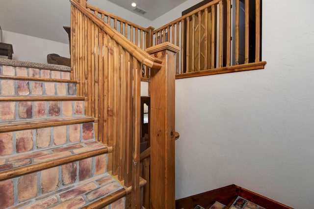 stairway with baseboards and a textured wall