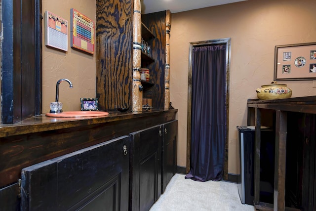 bathroom featuring a textured wall and vanity