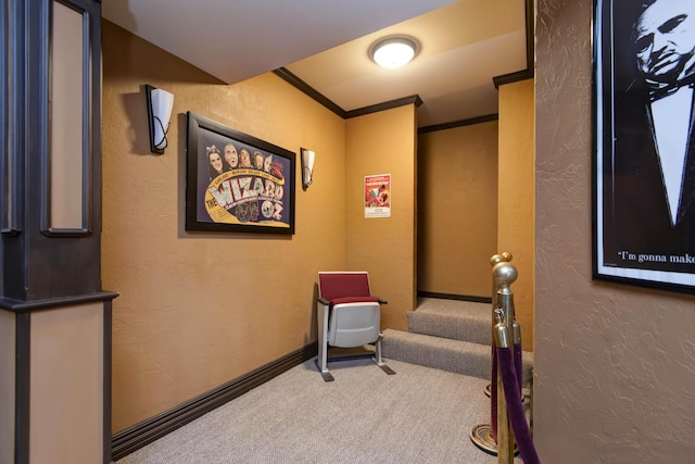 hall with stairway, carpet flooring, baseboards, ornamental molding, and a textured wall
