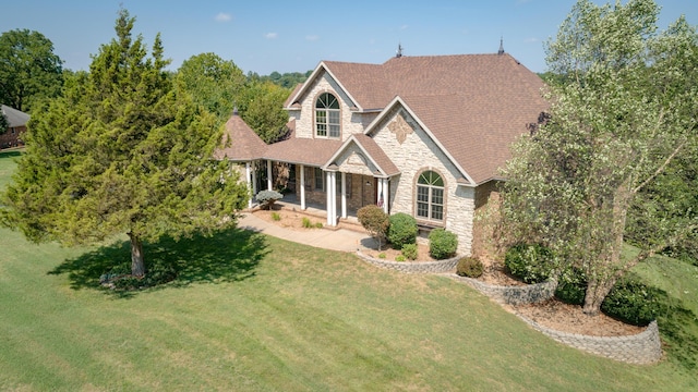 1321 E River Oak Dr, Springfield, MO 65803 - traditional-style home featuring stone siding, a front lawn, and roof with shingles