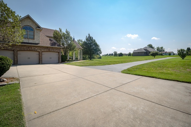 1321 E River Oak Dr, Springfield, MO 65803 - view of home's exterior featuring a lawn, stone siding, a garage, and concrete driveway