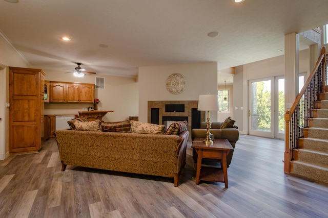 1321 E River Oak Dr, Springfield, MO 65803 - living area with a tile fireplace, visible vents, stairway, and wood finished floors