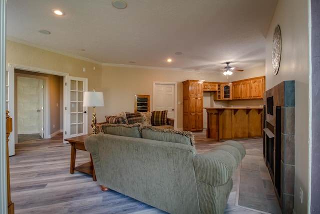1321 E River Oak Dr, Springfield, MO 65803 - living area with crown molding, light wood-type flooring, recessed lighting, ceiling fan, and a tiled fireplace