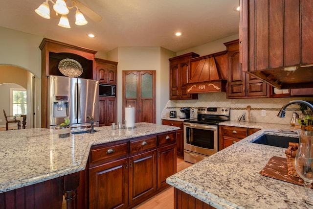 1321 E River Oak Dr, Springfield, MO 65803 - kitchen with custom range hood, stainless steel appliances, decorative backsplash, a sink, and arched walkways