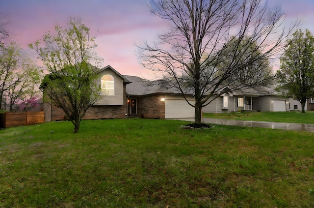 view of front of property featuring fence, a garage, a lawn, and concrete driveway
