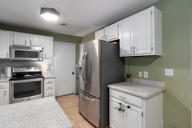 kitchen featuring white cabinets, visible vents, light countertops, and appliances with stainless steel finishes