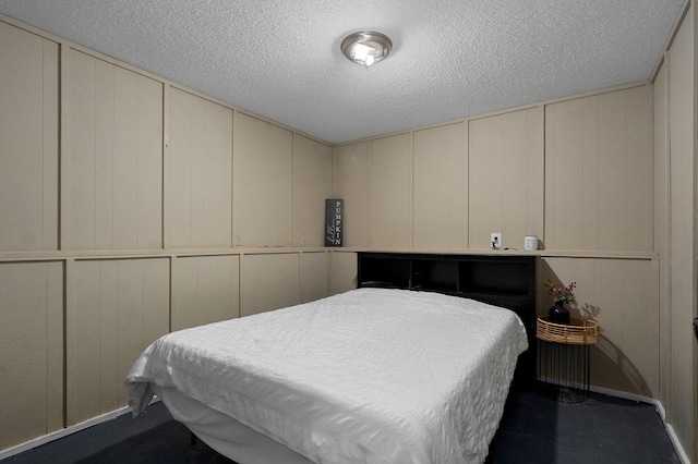 bedroom with a textured ceiling and a decorative wall