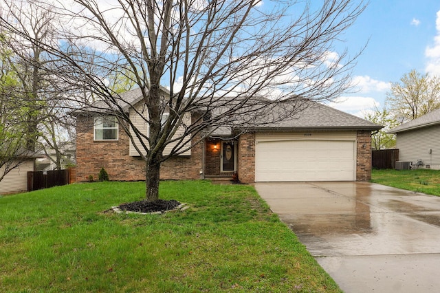 view of front of house with a front yard, fence, brick siding, an attached garage, and driveway