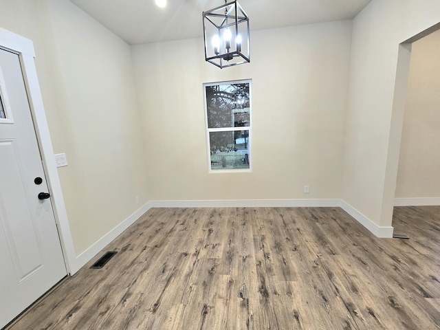 1511 W Lee St, Springfield, MO 65803 - unfurnished dining area featuring wood finished floors, visible vents, a notable chandelier, and baseboards