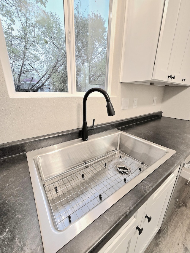 1511 W Lee St, Springfield, MO 65803 - details featuring white cabinetry, a sink, and dark countertops