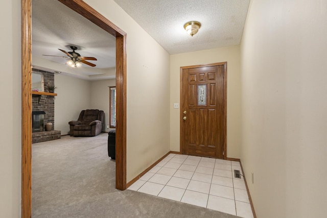 3740 W Glenwood Ct, Springfield, MO 65807 - foyer with light carpet, a fireplace, visible vents, and a textured ceiling
