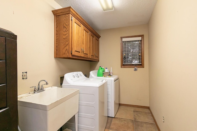 3740 W Glenwood Ct, Springfield, MO 65807 - laundry area featuring a textured ceiling, a sink, washer and dryer, baseboards, and cabinet space