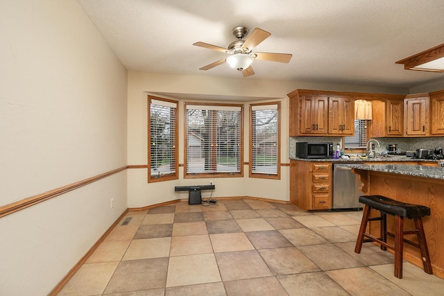 3740 W Glenwood Ct, Springfield, MO 65807 - kitchen with a ceiling fan, brown cabinets, black microwave, stainless steel dishwasher, and decorative backsplash