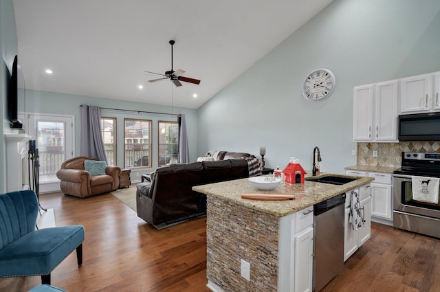 kitchen featuring ceiling fan, white cabinetry, appliances with stainless steel finishes, a sink, and open floor plan