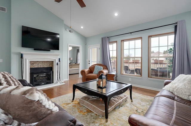living room featuring wood finished floors, visible vents, a ceiling fan, and a healthy amount of sunlight