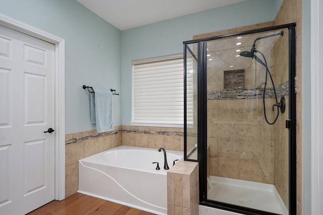 full bathroom featuring a shower stall, wood finished floors, and a garden tub