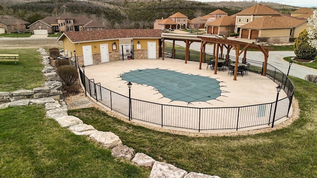 pool with a patio area, fence, a residential view, and a lawn