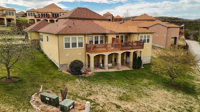 back of house featuring a wooden deck, stucco siding, and a lawn