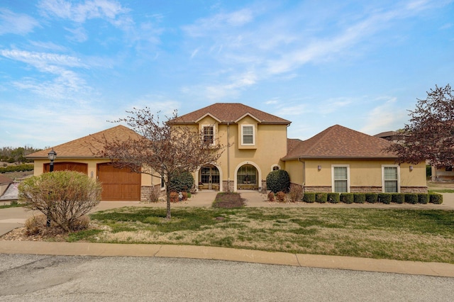 view of front of property featuring stucco siding, stone siding, a front lawn, a garage, and driveway