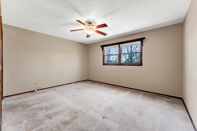spare room with light carpet, ceiling fan, and a textured ceiling