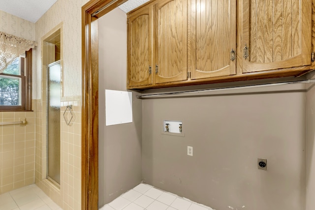 laundry room featuring cabinet space, electric dryer hookup, washer hookup, and wallpapered walls