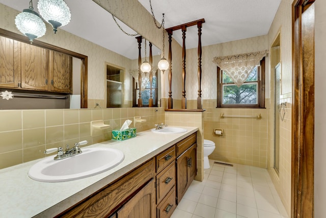 full bathroom with a sink, visible vents, a stall shower, and wallpapered walls