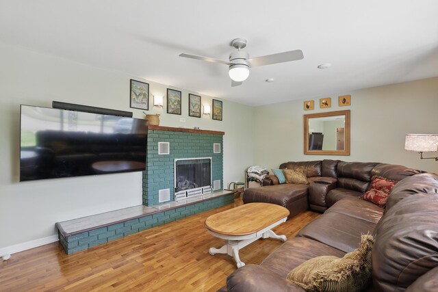 310 W Wishart Dr, Monett, MO 65708 - living area featuring wood finished floors, ceiling fan, a brick fireplace, and baseboards