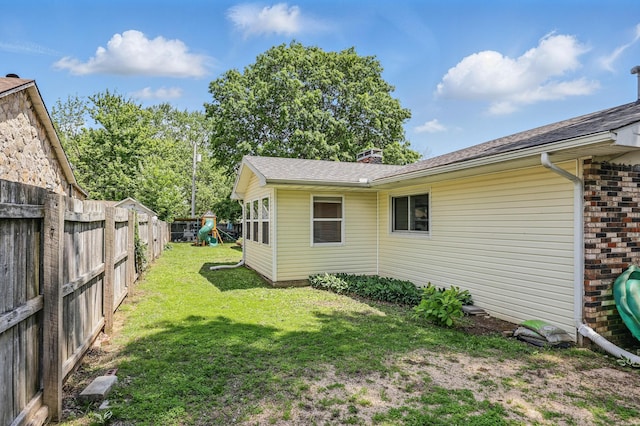 310 W Wishart Dr, Monett, MO 65708 - view of side of property featuring a playground, a chimney, and a shingled roof