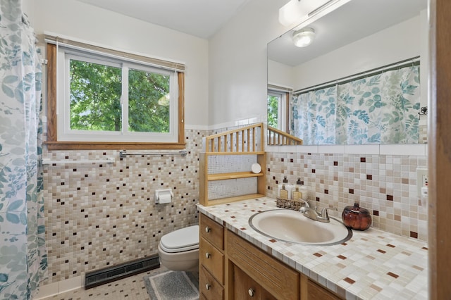 310 W Wishart Dr, Monett, MO 65708 - full bathroom featuring toilet, tile walls, vanity, a wainscoted wall, and curtained shower
