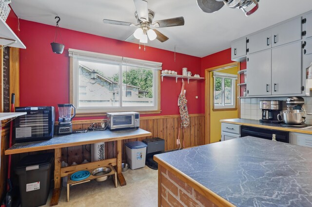 310 W Wishart Dr, Monett, MO 65708 - kitchen featuring ceiling fan, wainscoting, dishwasher, wooden walls, and backsplash