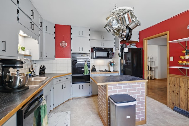 310 W Wishart Dr, Monett, MO 65708 - kitchen featuring black appliances, a warming drawer, tasteful backsplash, a center island, and dark countertops