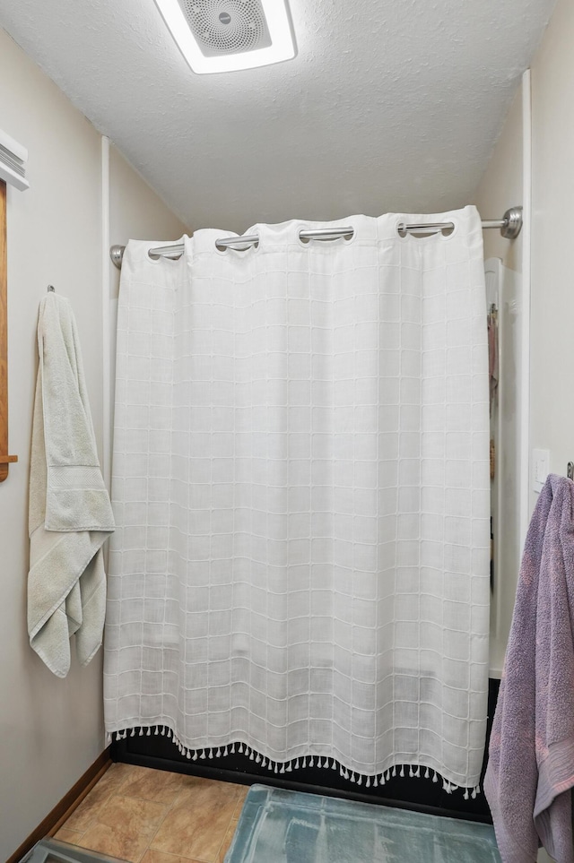 310 W Wishart Dr, Monett, MO 65708 - bathroom with a shower with curtain, a textured ceiling, and baseboards