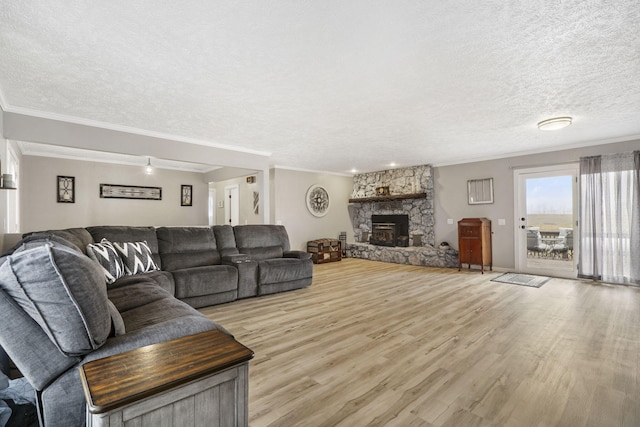 living room with a stone fireplace, a textured ceiling, and wood finished floors