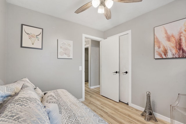 bedroom with a closet, light wood-style flooring, baseboards, and a ceiling fan