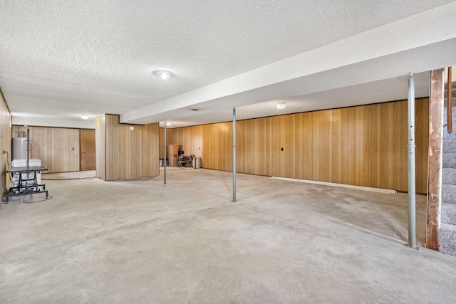 finished basement with a textured ceiling and wooden walls