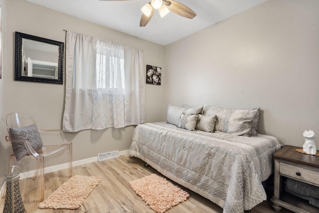 bedroom with visible vents, baseboards, a ceiling fan, and wood finished floors