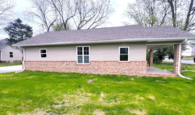 100 E Bond St, Monett, MO 65708 - view of side of property featuring a patio, a lawn, roof with shingles, and brick siding