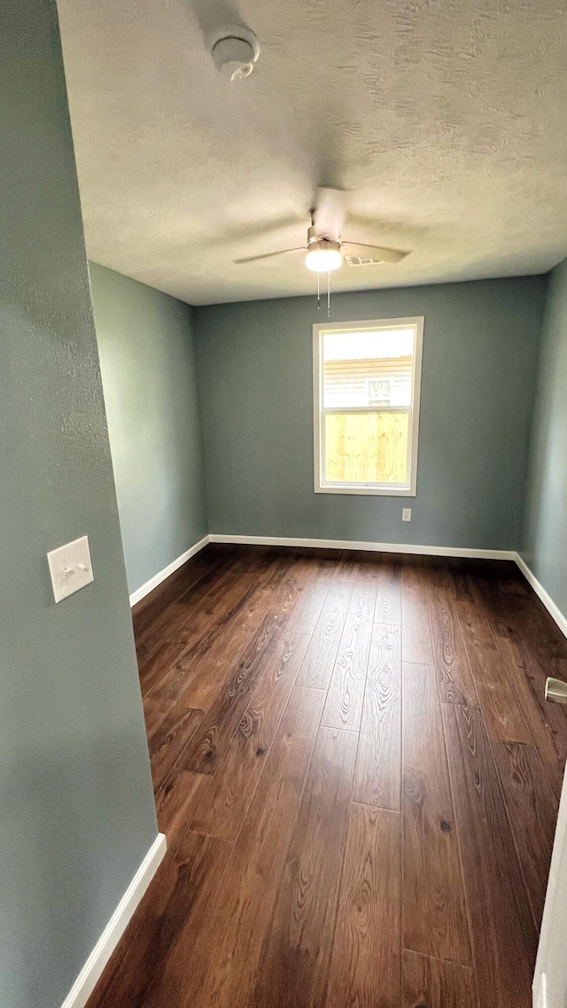 100 E Bond St, Monett, MO 65708 - spare room featuring a ceiling fan, a textured ceiling, baseboards, and dark wood-style floors