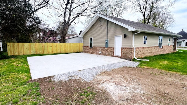 100 E Bond St, Monett, MO 65708 - view of home's exterior with a patio, brick siding, a yard, and fence