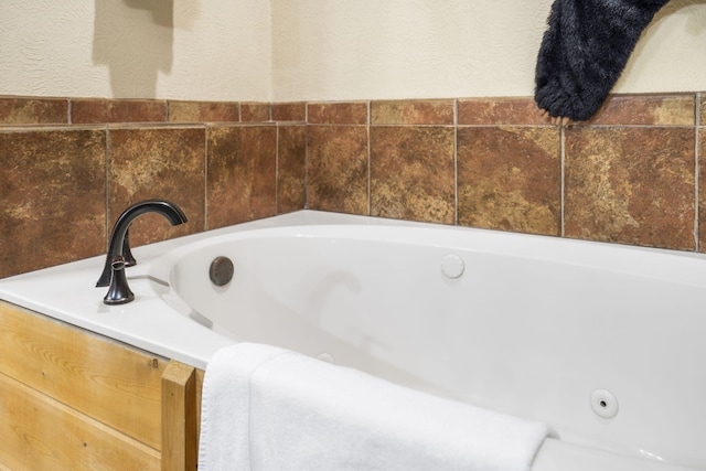 135 Rock Candy Ln, Branson, MO 65616 - full bath featuring a tub with jets and a textured wall