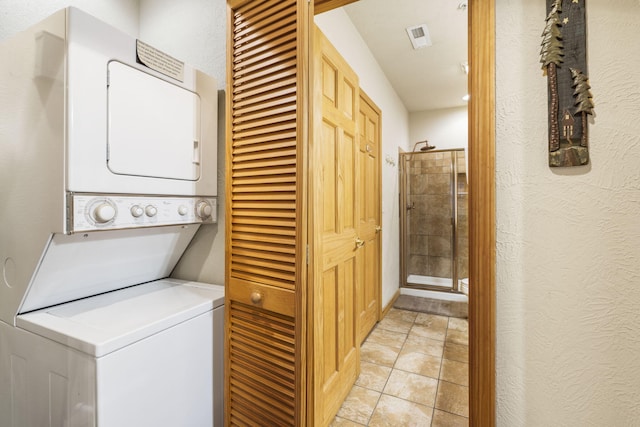 135 Rock Candy Ln, Branson, MO 65616 - laundry area featuring laundry area, light tile patterned floors, visible vents, a textured wall, and stacked washer / drying machine