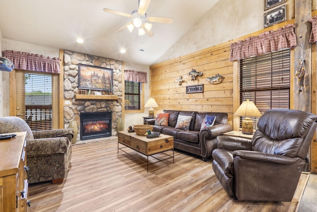 135 Rock Candy Ln, Branson, MO 65616 - living room with high vaulted ceiling, a fireplace, light wood-style flooring, a ceiling fan, and visible vents